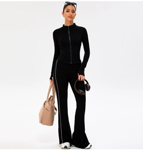 Slim fit black yoga set featuring a zipper jacket and flared leggings with side stripes
