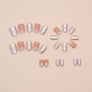 Press-on nail kit with 24 pieces featuring pink nude tones and silver 3D bow designs