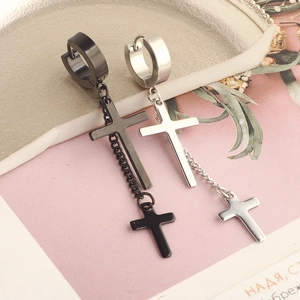 Macro view of black and silver stainless steel hoop earrings with cross and chain charm