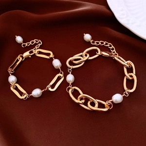 Detailed close-up of 18k gold-plated link chains and elegant pearls on satin fabric