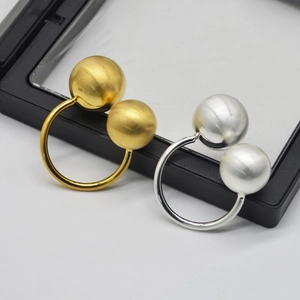Minimalist open sphere rings in gold and silver finish with brushed metal texture