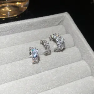 Sparkling zircon ear cuffs and ring set in silver tone on a grey velvet jewelry box