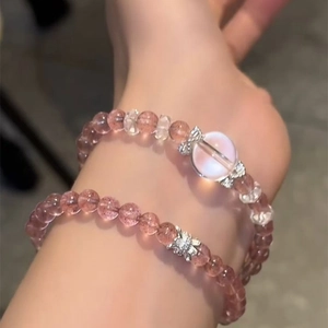 Detail of pink strawberry crystal double-layer bracelet with silver butterfly charm
