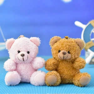 Close-up detail of pink and brown plush teddy bear keychains with golden ball chains