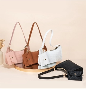 Detail of embossed leather underarm bags in four colors on a gold-rimmed mirror