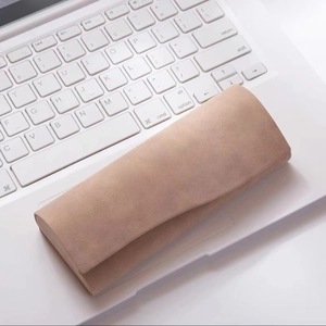Macro view of triangular camel suede sunglasses case on a laptop keyboard background