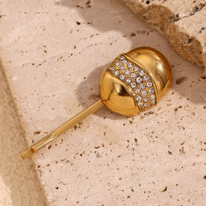Detailed macro view of 18K gold egg-shaped hair clip with sparkling pavé rhinestones