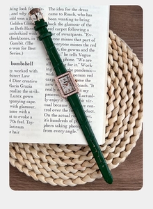 Dettaglio di orologio in pelle verde con quadrante rettangolare in oro rosa e diamanti