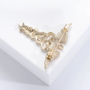 Golden Christmas tree brooch pin shown from the back view on a clean white background