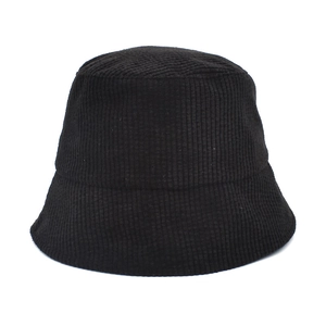 Close-up of black corduroy bucket hat showing soft ribbed texture and minimalist design