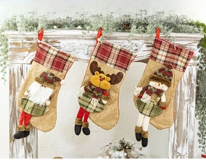 Three-piece knitted Christmas stockings with reindeer, Santa, and snowman hanging on a mantel
