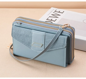 Close-up of light blue three-layer zip crossbody phone bag with gold metal hardware details