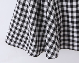 Detail of black and white gingham fabric with fine stitching and lightweight drape texture