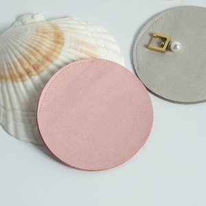 Detailed view of round microfiber jewelry pouches in pink and grey with fine stitching