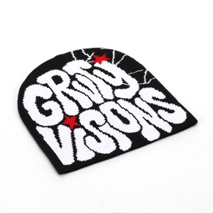 Détail d'un bonnet en maille avec texte Gray Visions et étoiles rouges sur tissu noir