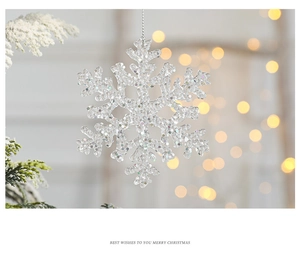 Macro shot of a transparent snowflake ornament with iridescent sequins and warm bokeh