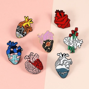 Set of seven artistic anatomical heart enamel pins featuring galaxy and floral designs