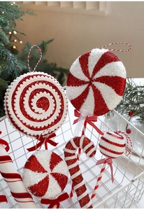 Close-up of red and white glitter Christmas candy ornaments in a white metal basket