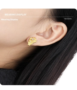 Detailed view of irregular textured gold earrings with inlaid crystals on female model
