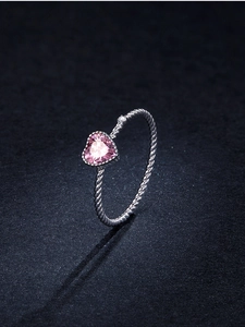 Macro shot of 925 silver heart ring featuring pink stone and twisted band design