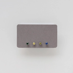 Macro shot of minimalist four-prong stud earrings set with colorful round zirconias