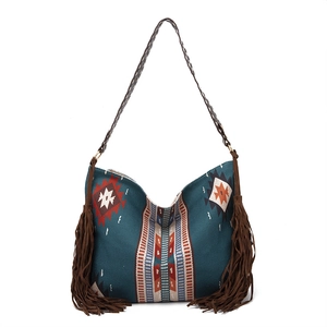 Macro detail of Bohemian woven tote featuring geometric tribal patterns and leather tassels