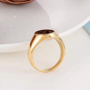 Macro shot of polished gold tone minimalist band ring with a flat top surface and glossy finish
