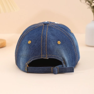 Rear view of denim baseball cap with yellow stitching and metal buckle on wooden stand