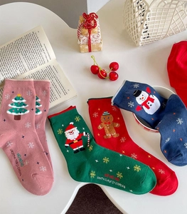 Flat lay of colorful Christmas socks featuring Santa, snowman and gingerbread patterns