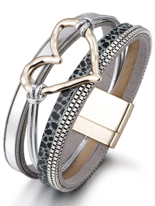 Dettaglio del bracciale multistrato con ciondolo a cuore dorato e motivo a serpente grigio