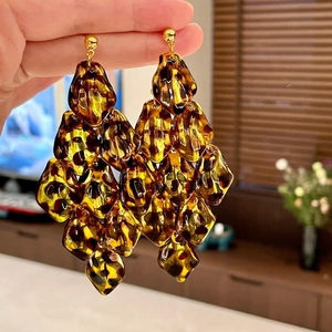 Close-up of tortoise shell acrylic petal tassel earrings with elegant golden studs
