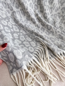 Close-up of leopard pattern cashmere-like scarf showing texture and fringe details