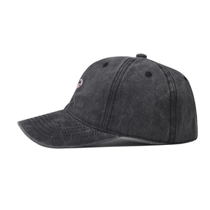 Close-up of washed cotton baseball cap featuring pink round embroidery and distressed texture