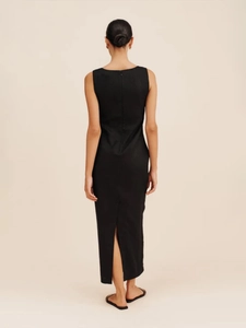 Detail view of the back of a slim fit black dress featuring a hidden zipper and center slit
