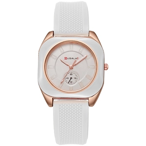 Detail of square rose gold watch with white silicone strap and textured band finish