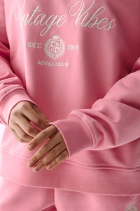 Détail du sweat-shirt rose avec broderie blason Vintage Vibes et texture de maille douce