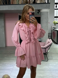 Detailed view of V-neck ruffled bodice and waist tie on pink chiffon dress