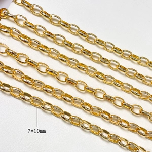 Macro detail of 7x10mm 14k gold-plated oval link chain on white leather background