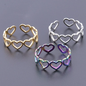 Minimalist heart-shaped open rings in gold, silver, and multicolor finishes on a dark background
