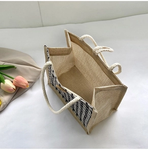 Close-up of woven jute tote bag with cotton rope handles and houndstooth pattern detail