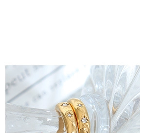 Macro shot of gold star-studded earrings with sparkling stones and polished finish