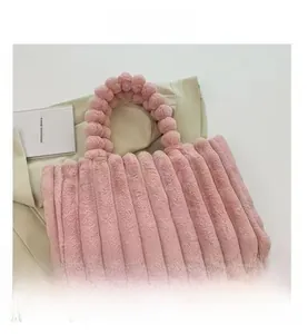 Detail showing plush pink faux fur texture and unique pom-pom handle on the tote bag