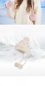 Dettaglio del cappello invernale in maglia con pompon soffici e fodera in calda pelliccia