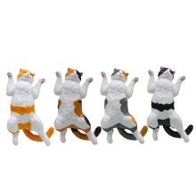 Detailed view of four different patterned cat figurines in lying positions on white background