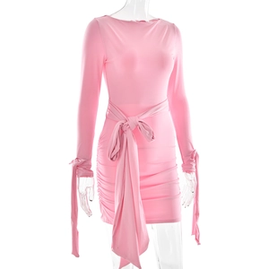Détail de la robe plissée rose avec nœud à la taille et poignets à rubans noués