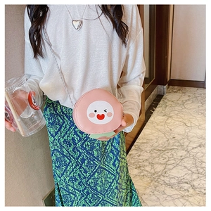 Girl wearing a cute pink peach crossbody bag with cartoon face and green leaf detail