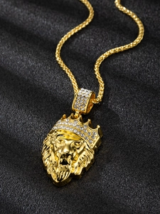 Macro detail of gold-plated lion head pendant with rhinestone crown on twisted chain