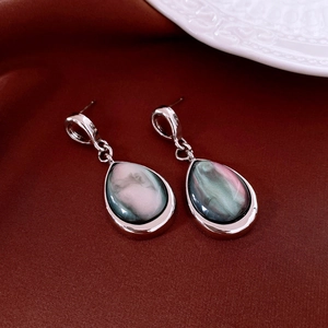 Detailed macro view of teardrop earrings with pink resin inlay on vintage silver base