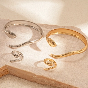 Two-piece gold and silver snake jewelry set featuring polished open bracelets and rings