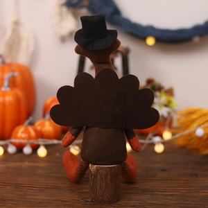 Detail einer Plüsch-Truthahnpuppe auf Holzfuß mit festlicher Kürbisdekoration